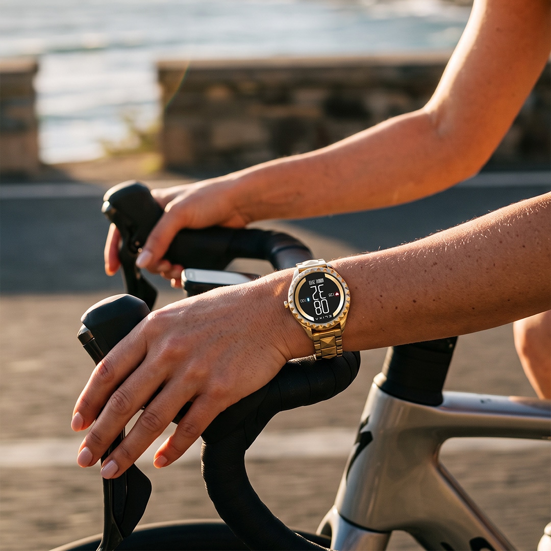 Złoty smartwatch sportowy na nadgarstku rowerzysty podczas jazdy na rowerze