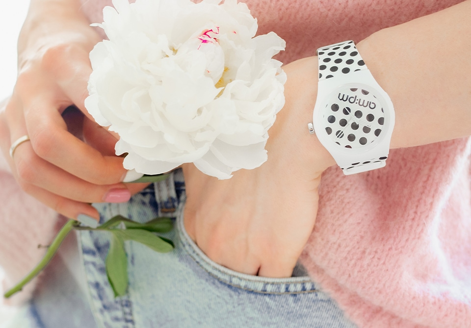 biały kwiat i zegarek założony na rękę