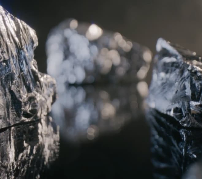 Lśniące bryły surowego minerału na ciemnym tle