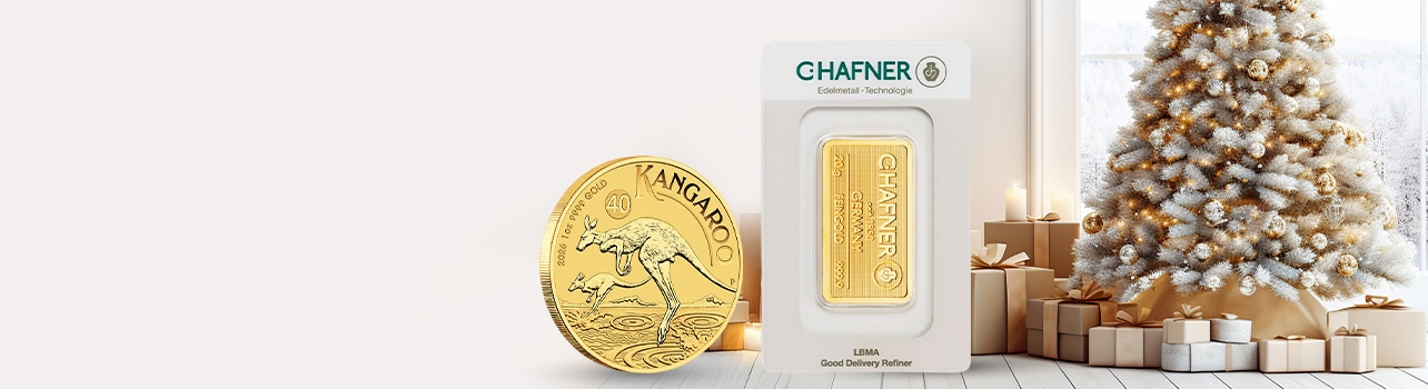 Złota moneta i sztabka C-Hafner na tle świątecznej choinki